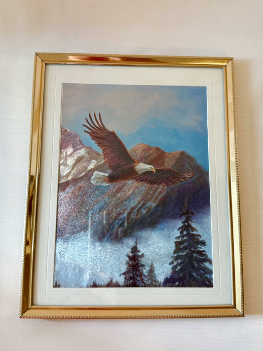 Framed painting of an eagle flying over mountains and trees.